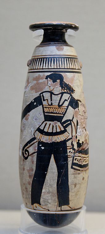 Amazon wearing trousers and carrying a shield with an attached patterned cloth and a quiver. Ancient Greek Attic white-ground alabastron, c. 470 BC, British Museum, London