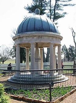A tomb in a garden covered by a circular roof
