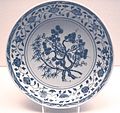 Plat de porcelaine de la dynastie Ming, avec un décor de branches d'arbre, de feuilles et une bordure florale