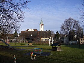 Spielplatz, Bauernhaus und reformierte Kirche in Kloten.