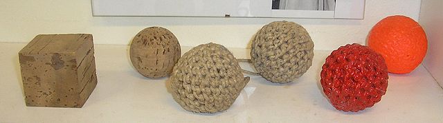 the making of a traditional bandy ball, from cork block to knitted, painted finish (with a modern ball to the far right) - British Bandy