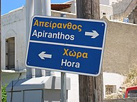 Signalisation routière en grec moderne avec transcription en alphabet latin à Naxos.