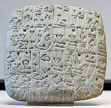Firkantet hvid tablet indskrevet med kileskrifttegn.  Louvre Museum.