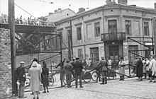 Corner of Zelazna 70 and Chlodna 23 (looking east). This section of Zelazna street connected the "large ghetto" and "small ghetto" areas of German-occupied Warsaw. Bundesarchiv Bild 101I-270-0298-10, Polen, Ghetto Warschau, Drahtzaun.jpg