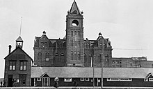 Calgary's original wooden Town Hall - built in 1885 - is dwarfed by the new City Hall being constructed right behind it in 1910 Calgary City Hall 1910 NA-2861-16.jpg