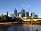 Melbourne gezeen vaanaof de zuidkant vaan de Yarra; Prinsebrögk op de veurgroond.