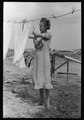Daughter of tenant farmer hanging up clothes near Warner, Oklahoma LCCN2017740119.tif