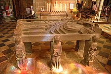 The flagstone depicting Saint Ronan viewed from the other side. The second reclining angel by Ronan's head is touching the top of the cross.