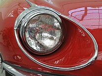 A 7 in (180 mm) round sealed-beam headlamp with lens optics on a Jaguar E-type. The flutes and prisms spread and distribute the light collected by the reflector. Jaguar E-type (serie III) - headlamp.jpg