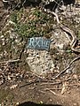 Bronze plaque embedded in the rock face next to the tombstone for James Jeffrey Roche in Holyhood Cemetery