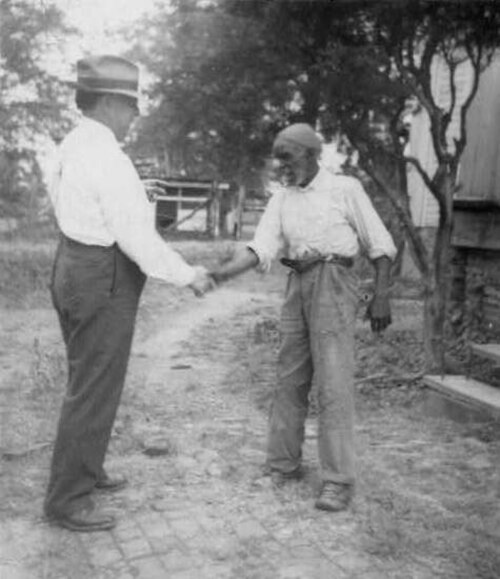 Musicologist John Lomax (left) shaking hands with musician "Uncle" Rich Brown in Sumterville, Alabama