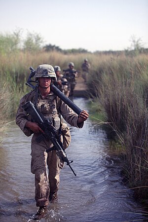 Lance Cpl. Derek Hopkins, a mortarman with Company K, 3rd Battalion, 7th Marine Regiment, carries a mortar tube while walking through a flooded field during a patrol, Aug. 3. Marines with Company K carry their mortar systems Lance Cpl. Derek Hopkins, a mortarman with Company K, 3rd Battalion, 7th Marine Regiment, carries a mortar tube while walking through a flooded field during a patrol, Aug. 3. Marines with Company K carry their mortar systems.jpg