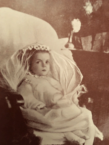 a child wearing a white first communion dress