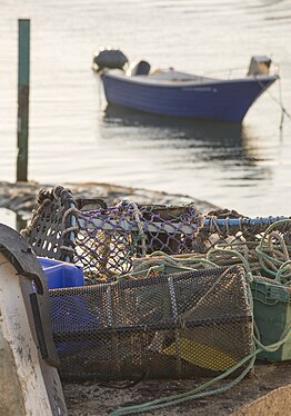 Lobster traps overlooking docked boat in Bude, UK