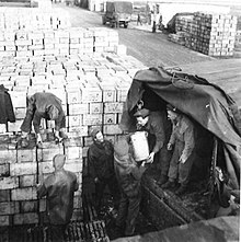 Lorries are loaded with supplies at No. 8 Army Roadhead Lorries being loaded with supplies of food at an Army Supply Depot.jpg