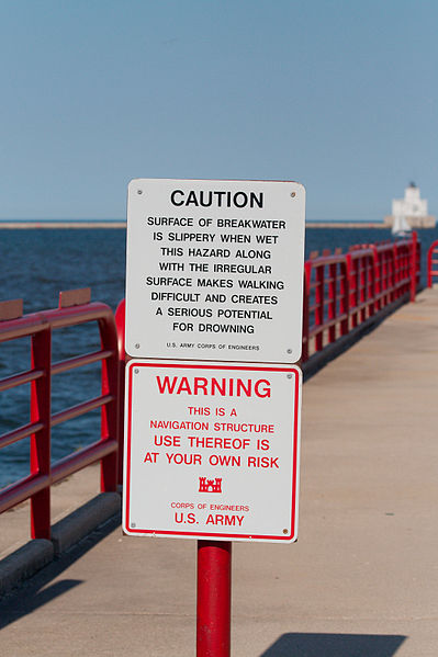 Harbor sign warning visitors that use of the walkway is "at your own risk"