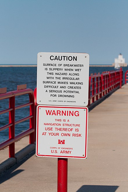 Harbor sign warning visitors that use of the walkway is "at your own risk"