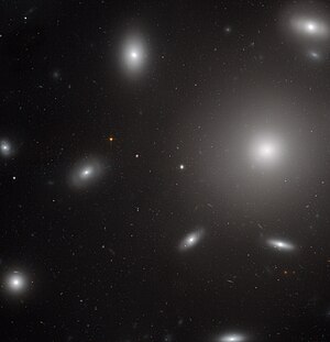 허블 망원경의 탐사용 고성능 카메라로 광대역에서 촬영한 광학 및 근적외선 사진, NGC 4874는 사진에서 가장 큰 은하이다.