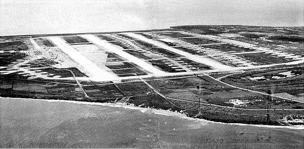 Oblique airphoto of North Field, Tinian, 1945, showing the massive runway system and number of hardstands. On each hardstand, a B-29 was parked and ma