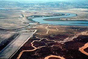 Belmont Slough (1970), view directed southwest. This was taken before the development of Redwood Shores (east of the Slough, on the left side of this photograph) and Foster City (west / right). The southern tip of Bat Ray Island is visible within the Slough.