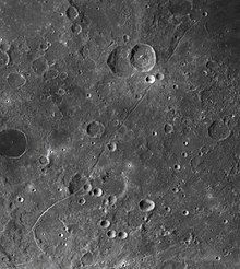 Imagem da vista superior da superfície lunar, com crateras difusas.