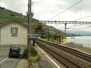 Zweistöckiges Bahnhofsgebäude neben der zweigleisigen Eisenbahnlinie