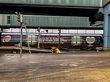 A side view of 3006 ('trainbow' livery) whilst departing from Belfast Lanyon Place railway station.