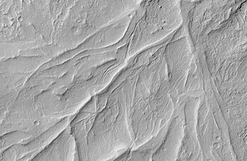 Crêtes sinueuses dans la région de Medusae Fossae, au sud d'Amazonis Planitia, illustrant les reliefs inversés révélant d'anciens lits de cours d'eau durcis par cimentation, vues par MRO le 8 avril 2008[107].