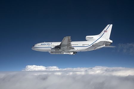 Photographed from the F-18 pathfinder aircraft, the Orbital ATK L-1011 Stargazer aircraft is seen flying over the Atlantic Ocean offshore from Daytona Beach, Florida. Attached beneath the aircraft is the Pegasus XL rocket with eight Cyclone Global Navigation Satellite System, or CYGNSS, spacecraft.