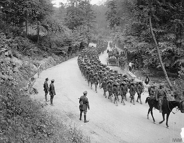 Men of the 307th Infantry Regiment (attached to the British 42nd Division for instruction), headed by a British regimental band, marching past Major-G