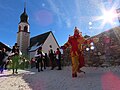 The jester (called 'bajatzl') in red and yellow leads the procession throwing snow in the air, pulling pranks and climbing roofs