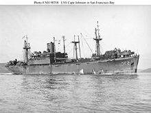Photo de profil en noir et blanc du navire USS Cape Johnson naviguant dans la baie de San Francisco.