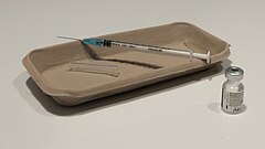 Vial and syringe used for first COVID-19 vaccination.jpg