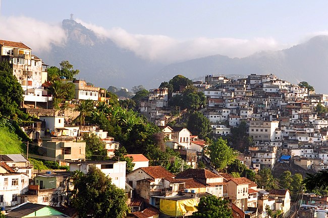 Rio's Santa Teresa neighborhood features favelas (right) contrasted with more affluent houses (left). The Christ the Redeemer, shrouded in clouds, is in the left background.
