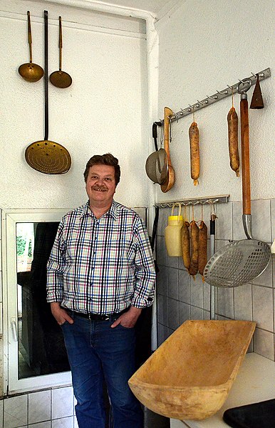 File:2014-04-12 Friedrich-Wilhelm Busse privat mit selbstgemachten Würsten und historischen Schlachterutensilien wie etwa Siedekellen und Holztrog.jpg