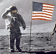 David Scott hormat kepada bendera Amerika selama misi Apollo 15. Lengan crosshair hanya muncul pada garis-garis merah bendera (Photo ID: AS15-88-11863)