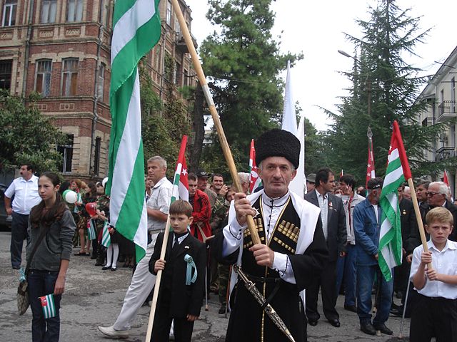 Abkhazians carrying the republic's flags in a parade