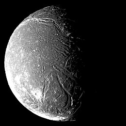 the dark face of Ariel, cut by valleys and marked by craters, appears half in sunlight and half in shadow