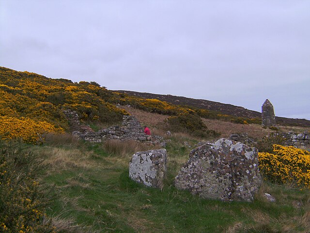 Ruins of the Badbea longhouses with the 1911 monument in the background