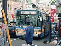10系統と93系統には車掌が乗務し（左）、杉田駅前では車外に出てバスを誘導していた（右）（1994年12月10日撮影）