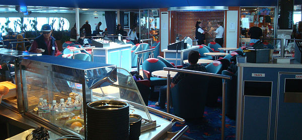 Main dining and lounge area, with two crew members about to open the gift shop in the background