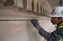 A mason removes old mortar during repointing work at the Cannon House Office Building, Washington, D.C. Cannon Renewal Project - June 2017 (35511277590).jpg