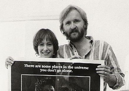 James Cameron and Gale Anne Hurd holding a theatrical poster for Aliens in 1986