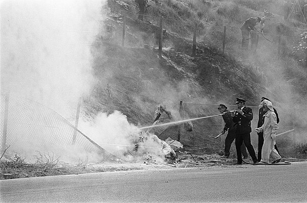 The burning wreck of Piers Courage being extinguished