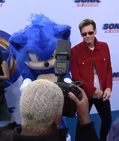 Jim Carrey, who plays Doctor Robotnik for the live-action films, posing with an individual dressed in a mascot costume that replicates Sonic's redesig