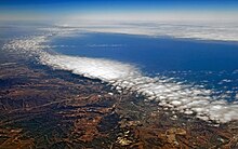 A weak, shallow layer of clouds hovering over the coast of California, typical of the dissipation of the marine layer later in the day. JuneGloom.jpg