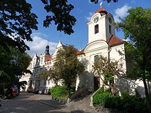 Pfarrkirche St. Gotthard in Bubeneč, im Hintergrund das ehemalige Rathaus