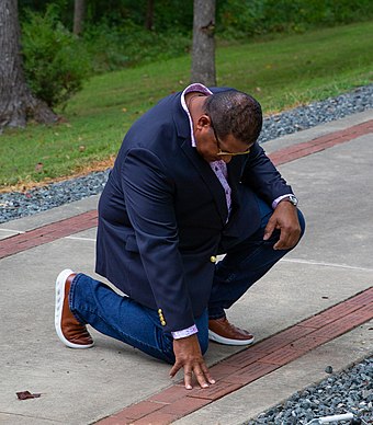 Clemente's son, Luis, lays a brick in honor of Clemente at the National Museum of the Marine Corps