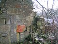 The gable end of a building at Millburn. Note the very unusual elongated window set towards the front of the house and the old bricked up doorway.