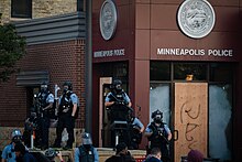Police guard the third precinct the day before it was burned down during the George Floyd protests. Minneapolis Police guarding 3rd Precinct May 2020.jpg